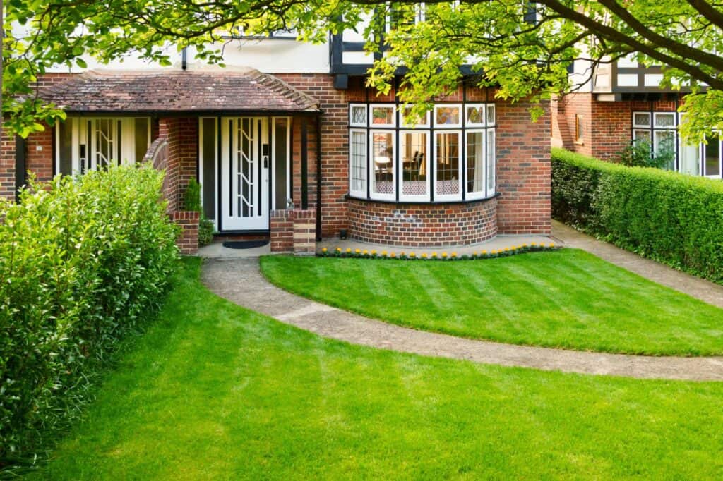 A brick house with a front lawn