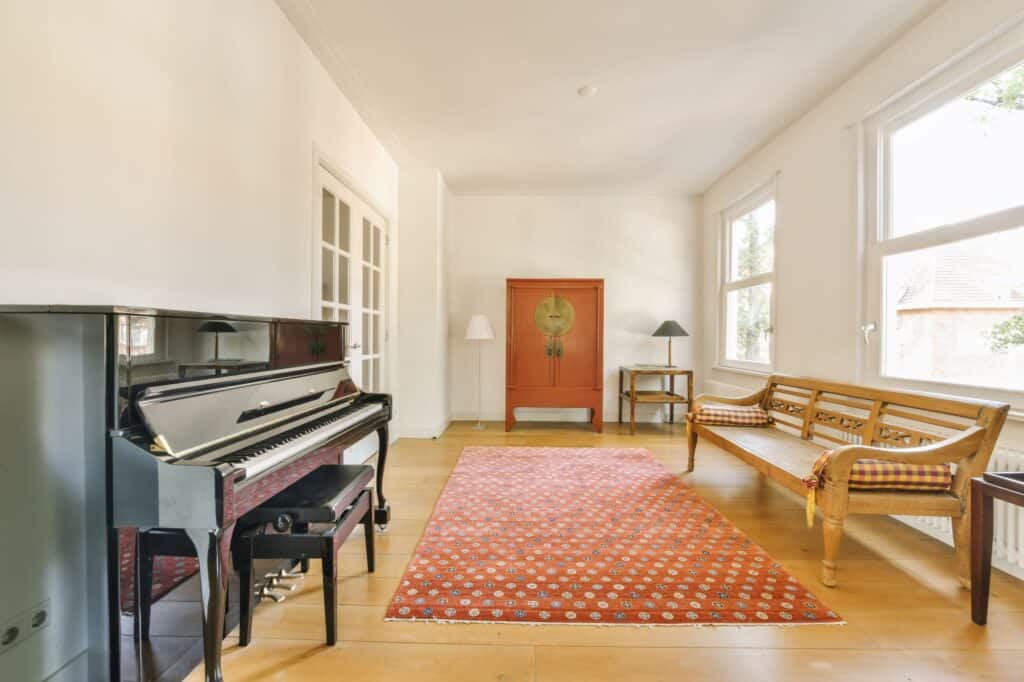 A spacious living room with a piano and a couch