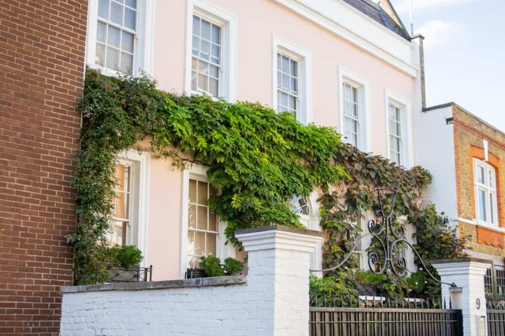 A house covered with climbing plants in the concept of considerations when relocating to Islington.