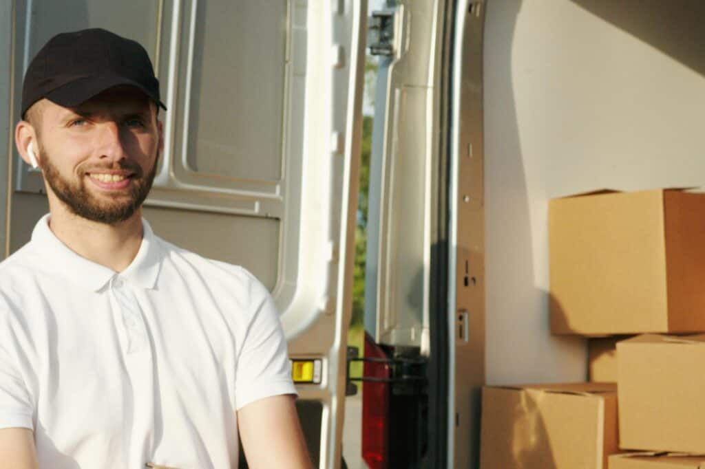 A mover is at the back of the van full of boxes