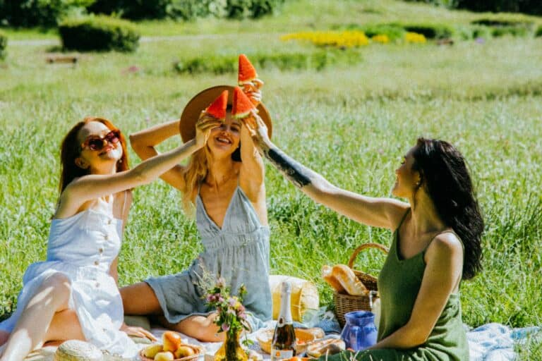 Friends having picnic on a sunny day in the concept of 'best parks and green spaces in Islington'.