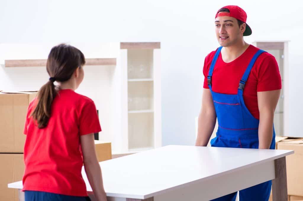 Movers carrying a table during the house relocation day